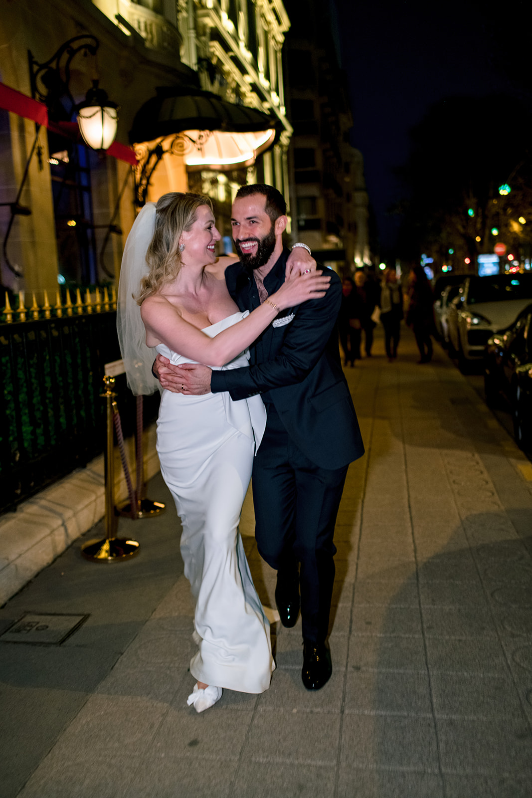 Bride and groom embracing during their Avenue Montaigne wedding walk